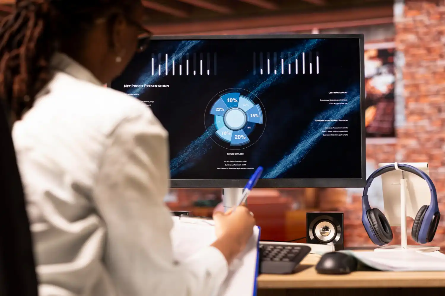 Pessoa analisando dados de BI em tempo real em frente a um monitor com gráficos e estatísticas, destacando a importância da tomada de decisão rápida com dados instantâneos.